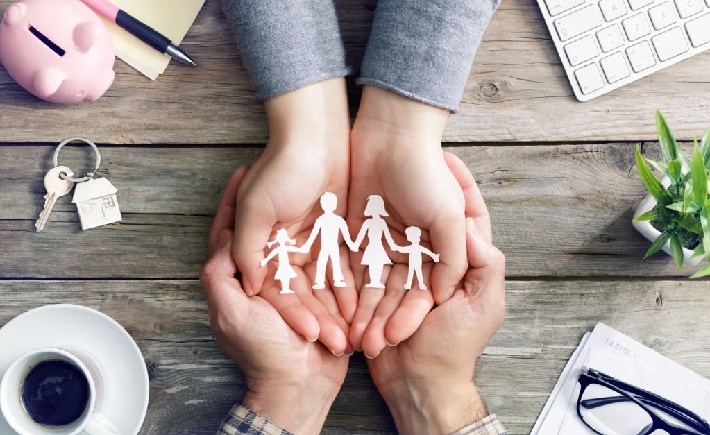 employee holding hands with a family cut out in their hands